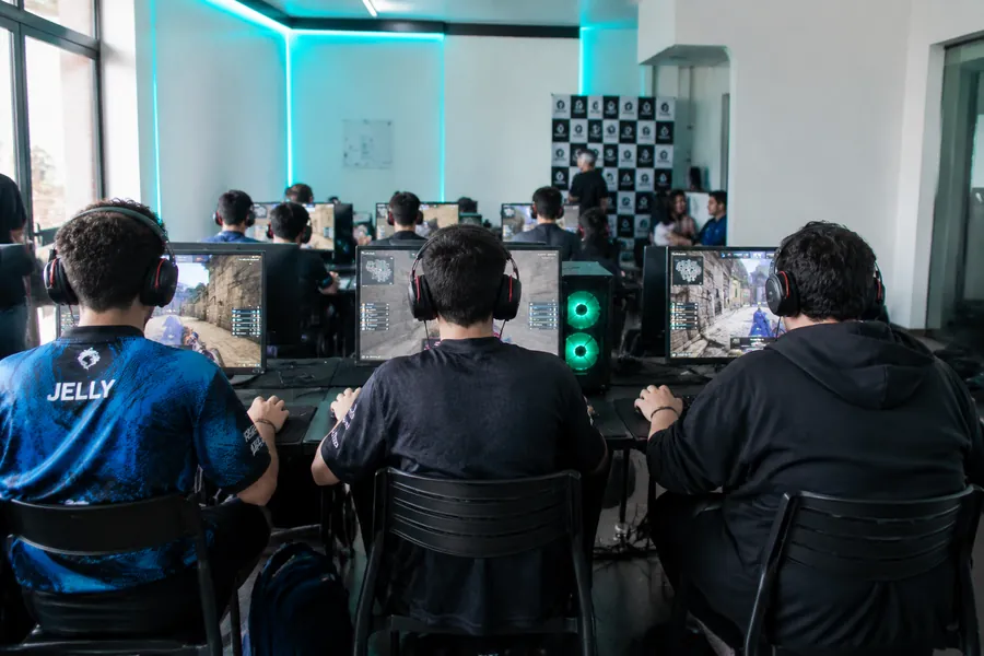 Jugadores de espaldas compitiendo en un torneo interno de Píxel Café Perú.
